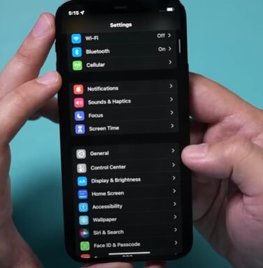 A person holding an iphone x with a screen showing the settings