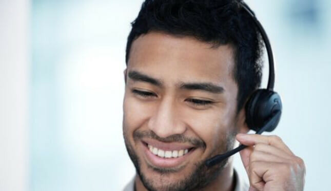 A man smiling while wearing a headset
