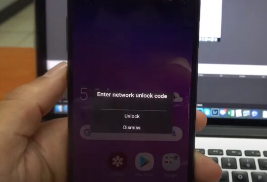 A person is holding a phone with a message displayed that says: Enter network unlock code