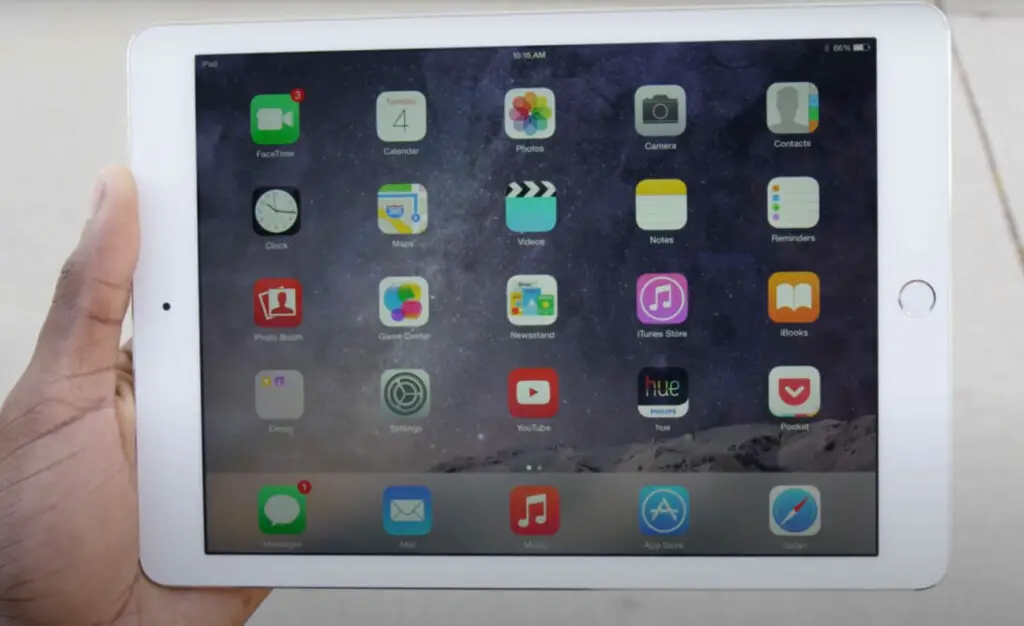 A person holding an ipad air with a lot of app icons on it