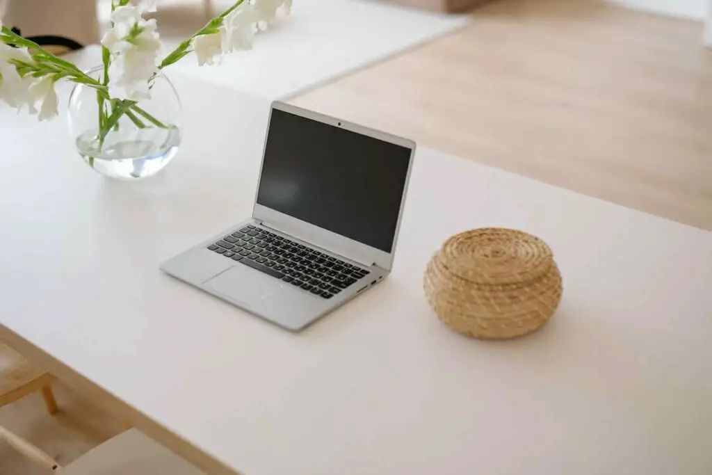 A laptop is sitting on a white table in a living room