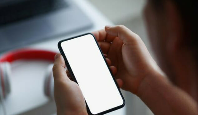 A person holding a phone with a blank screen