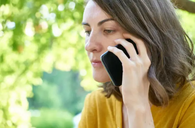 A woman talking on a cell phone in a park