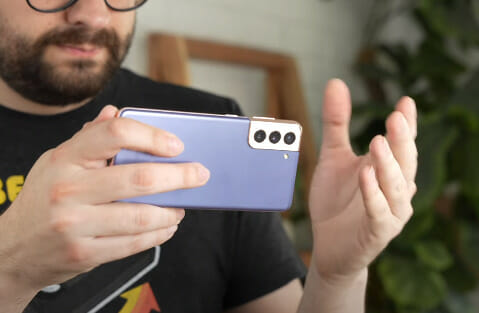 A person holding horizontally a purple phone