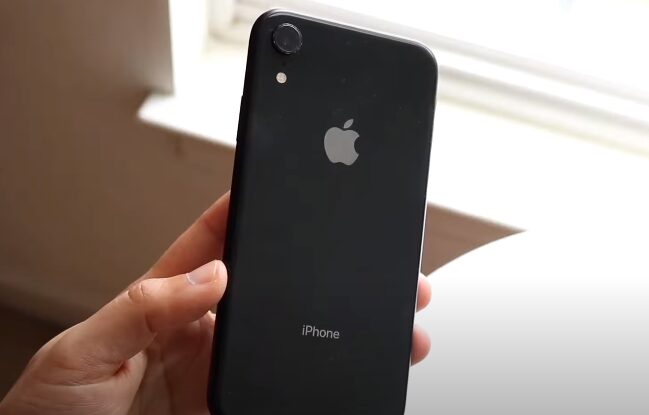 A person holding a black iphone