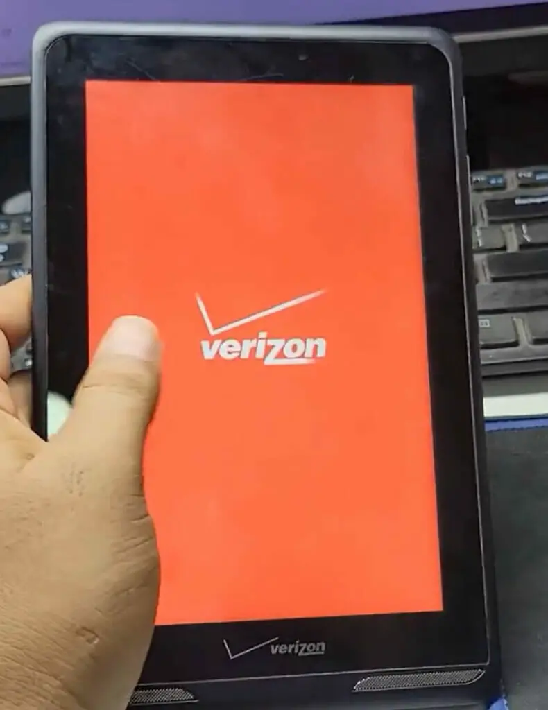 A person holding a tablet with the verizon logo on it