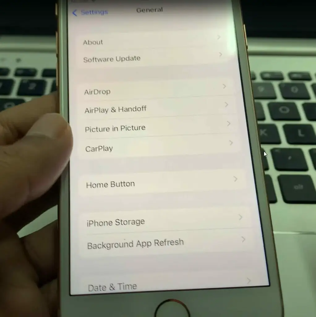 A person showing the General list of iPhone setting