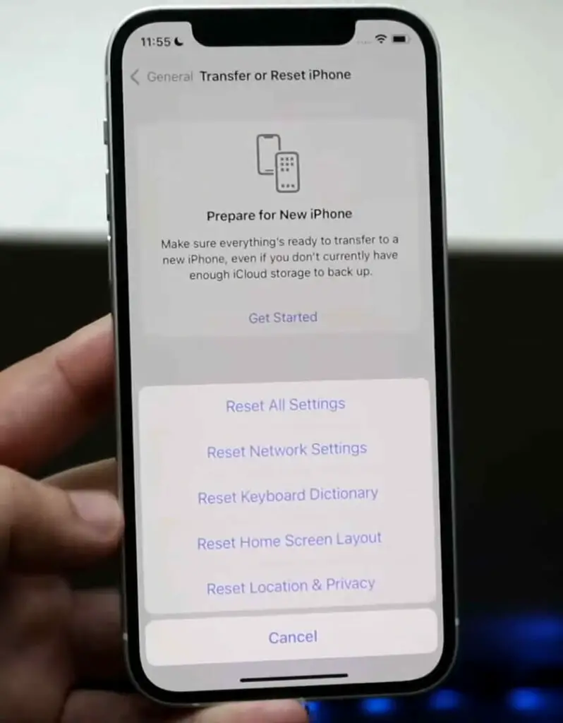 A person holding an iPhone displaying the'restore from backup' option