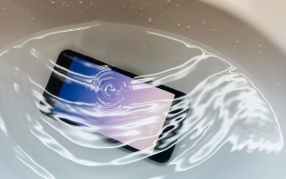 A cell phone floating in water in a sink