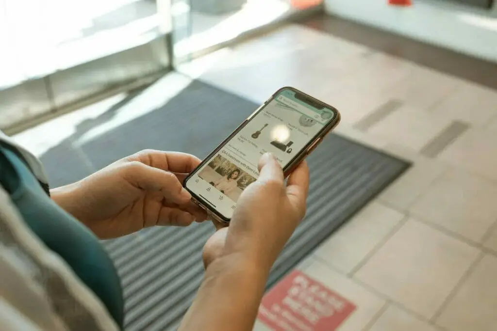 A woman using a smart phone while standing in front of a door