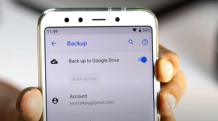 A person is holding up a phone with the backup option on it