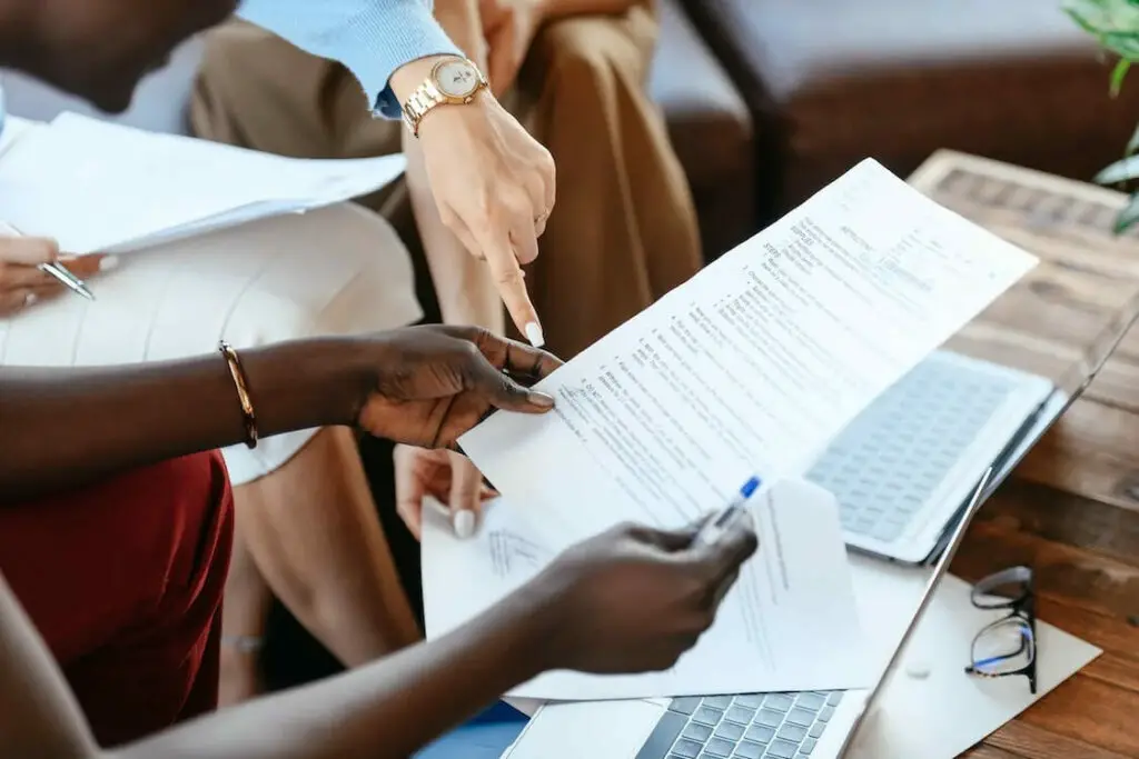 A group of people sitting around a table looking at paperwork