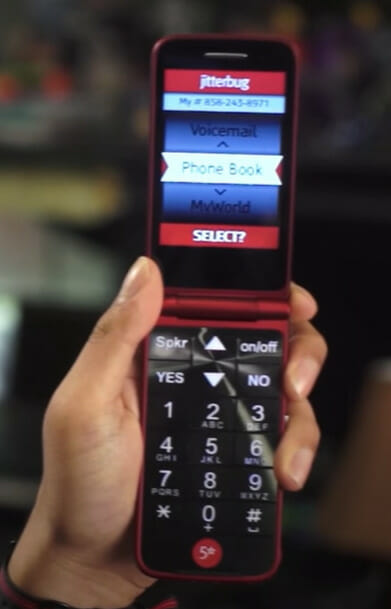 A person holding up an opened flip phone