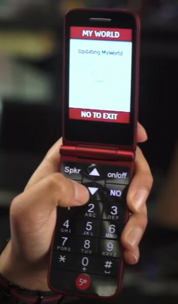 A person holding up a cell phone with a message on it