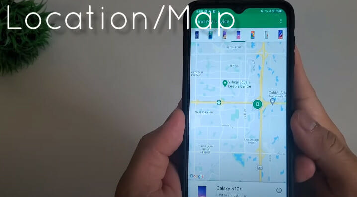 A person is holding up a phone with a location map on it