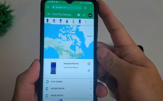 A person is holding up a phone with a map of the phone location