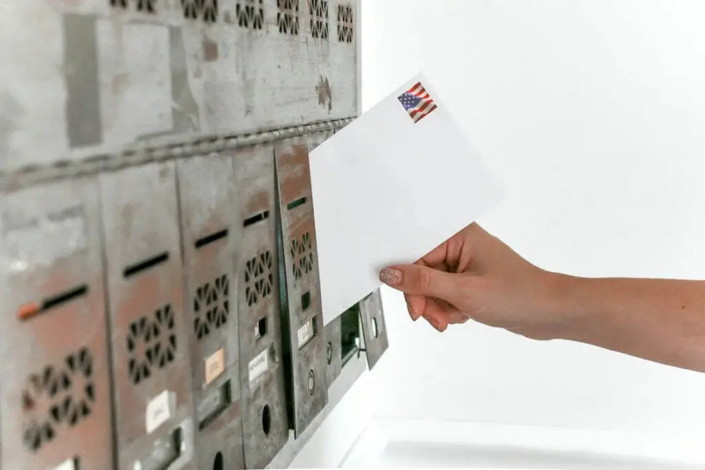 A person dropping an envelope to a PO box