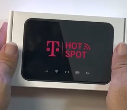 A persol holding a box of a T Mobile Hot Spot device