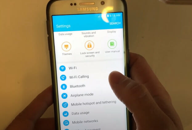 A person holding a Samsung phone showing the Setting list option