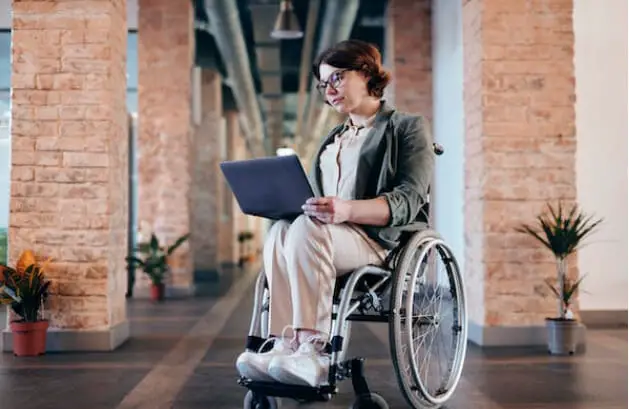 A woman in a wheelchair using her laptop