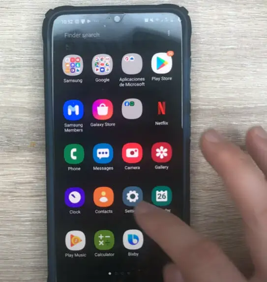 A person tapping on the setting icon on the phone's homescreen