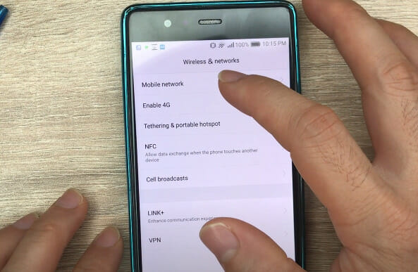 A person tapping on Mobile network setting on the phone