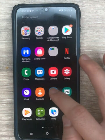 A person tapping the Setting icon wrench from a mobile's screen