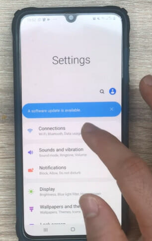 A person tapping the Connections option on the phone's Settings