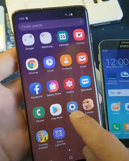 A person with two phone and one pointer finger tapping on the Setting icon