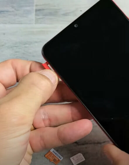 A person inserting a sim card on the phone