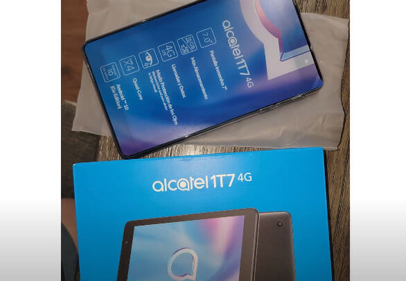 An alcatel tmio tablet is sitting on a table next to a box