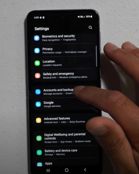 A person tapping on Accounts and backup setting on the phone