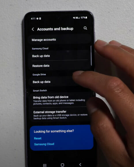 A person tapping on 'Accounts and back up' setting on the phone