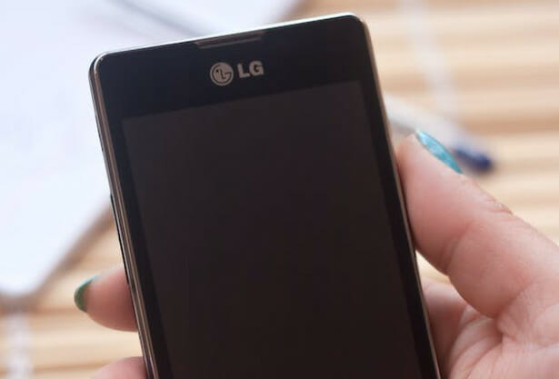 A woman holding an LG black phone