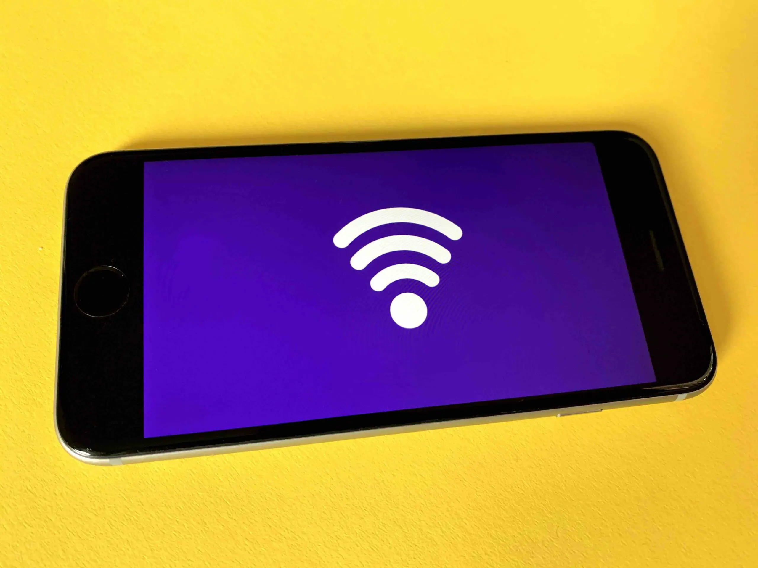 A phone with a wi-fi icon in a yellow background