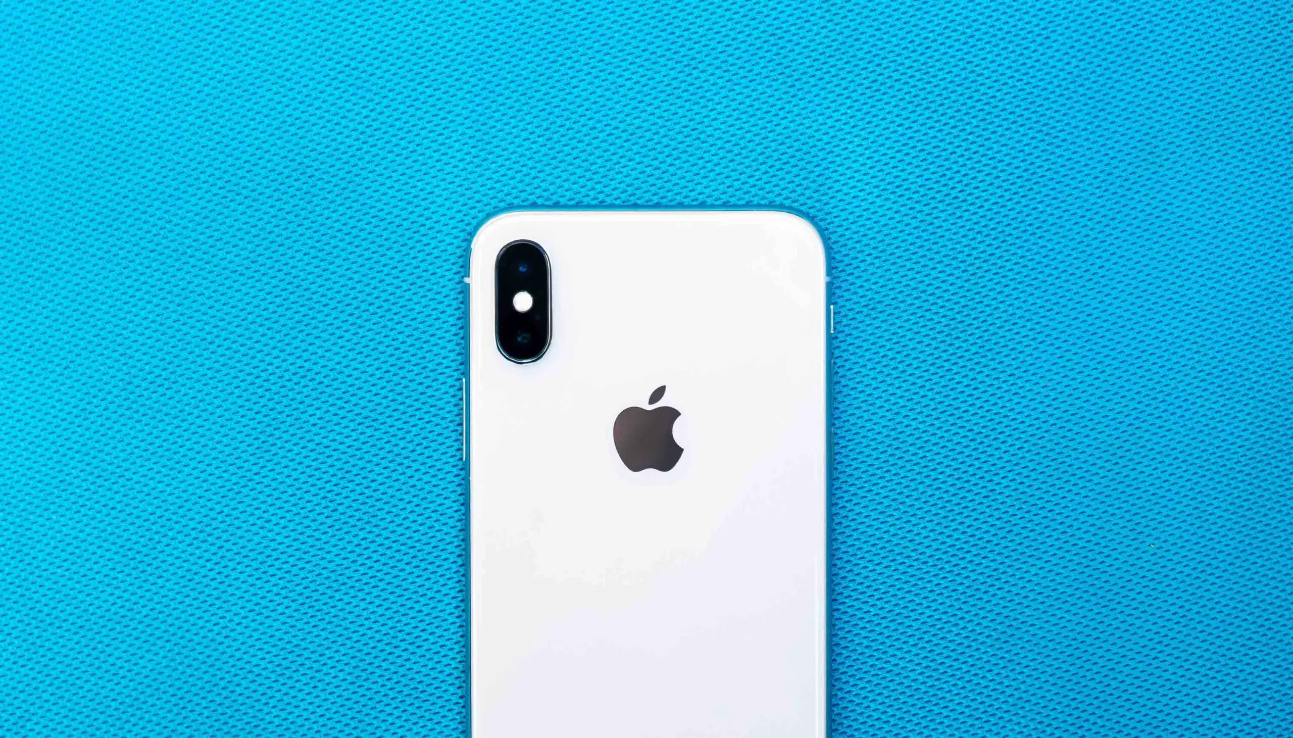 An iphone in a blue cloth background