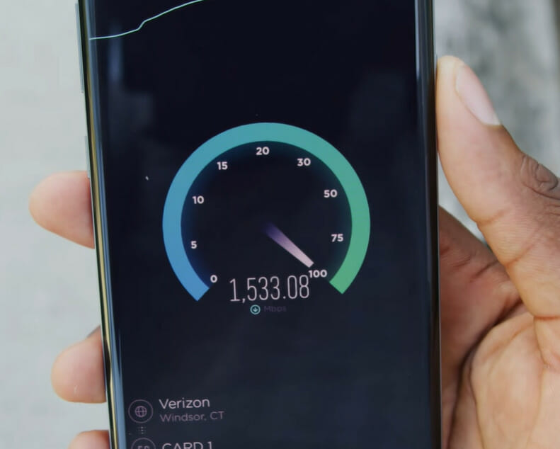 A person holding a phone performing internet speed test of a Verizon connection