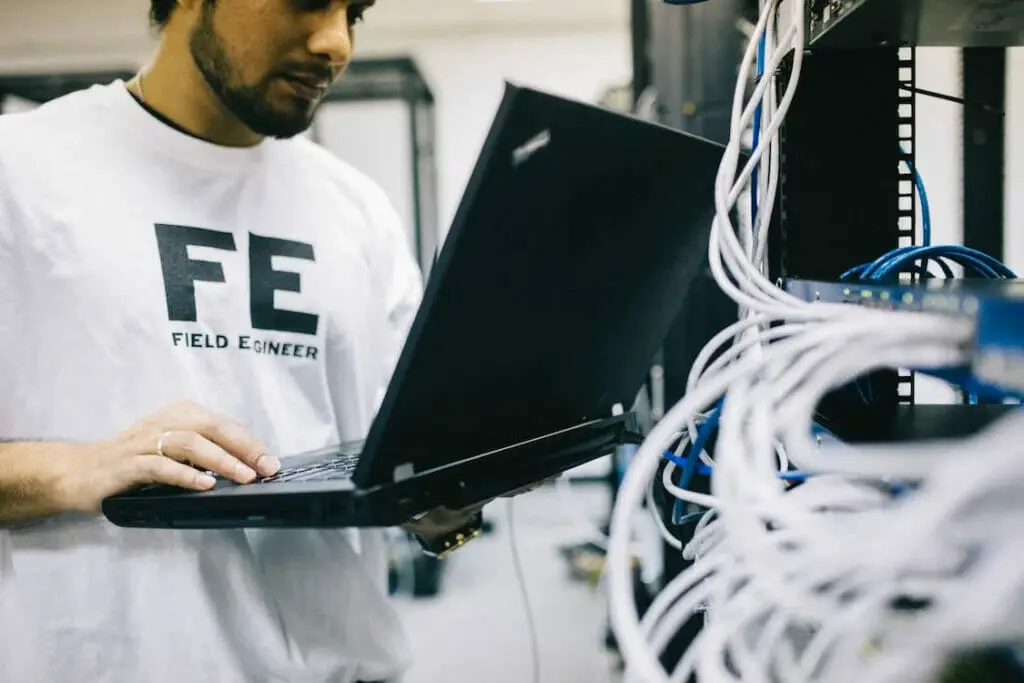 A Field Engineer holding a laptop in a server room