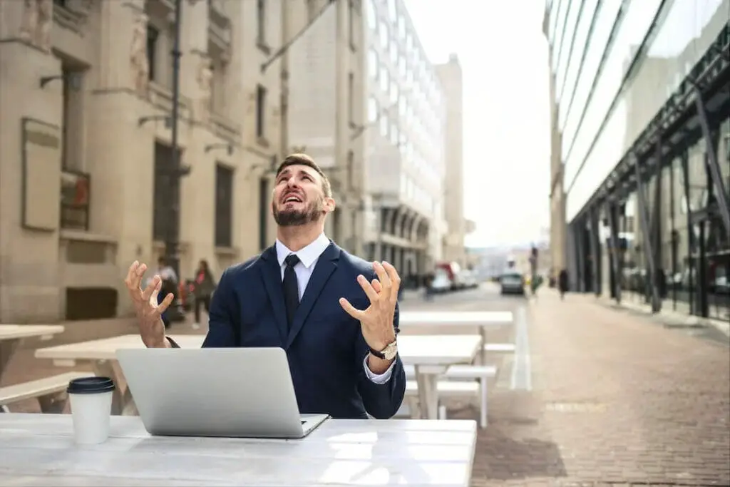 A man in the suit having problems with his laptop
