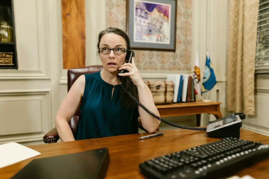 A woman sitting at a desk talking on the phone