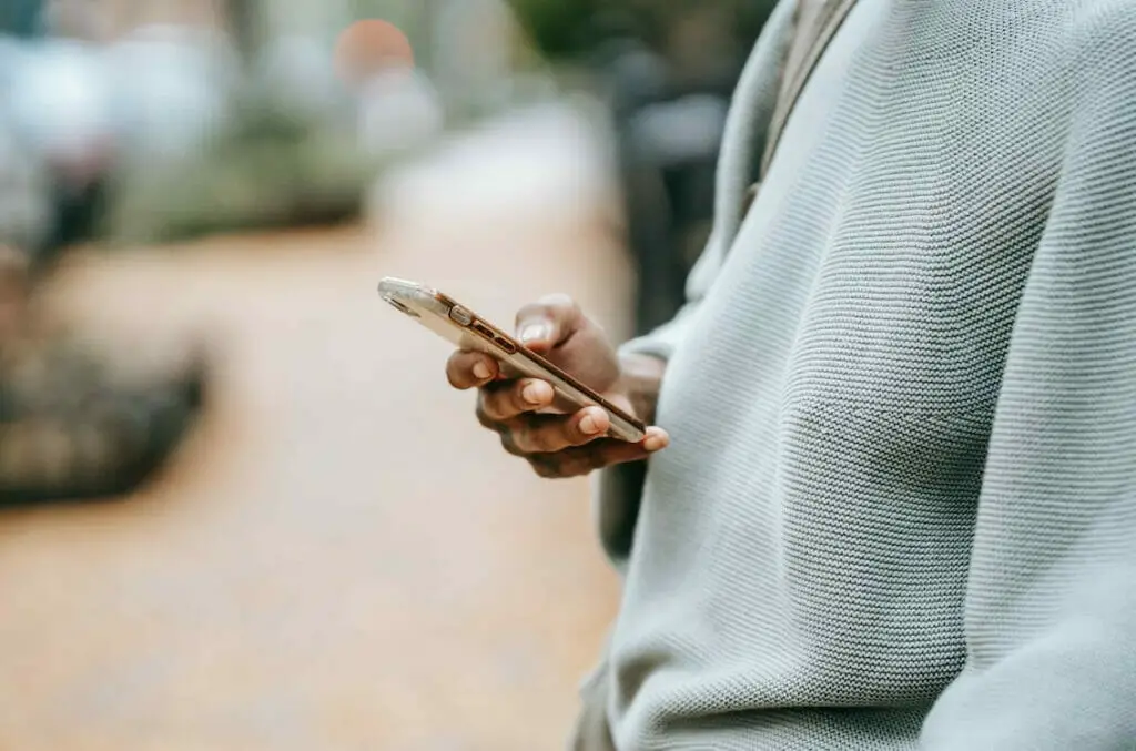 A person holding a cell phone on a street