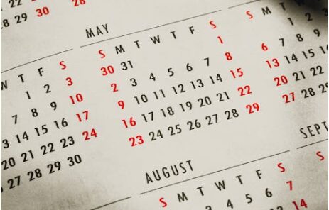A close up of a calendar with red numbers