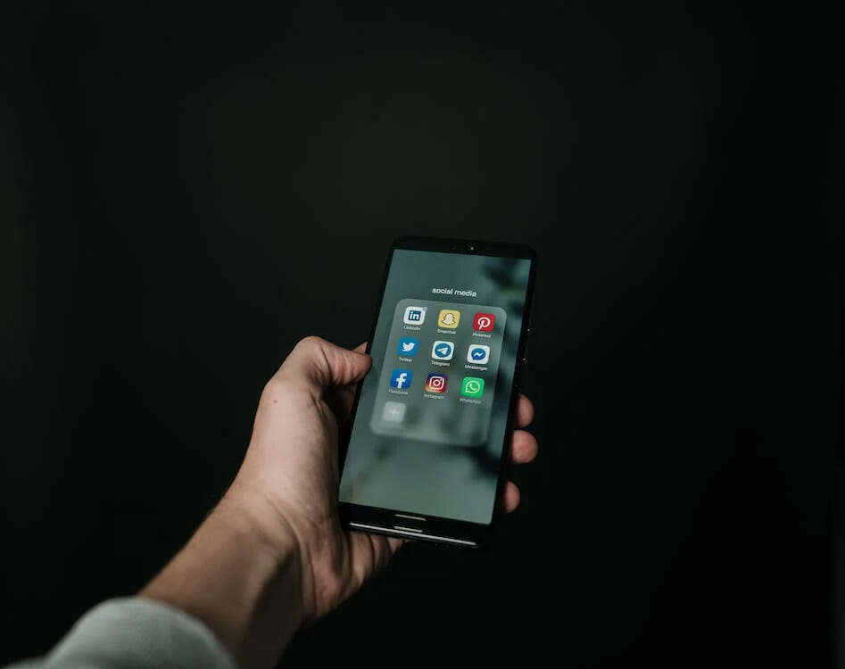 A person holding a phone in a black background