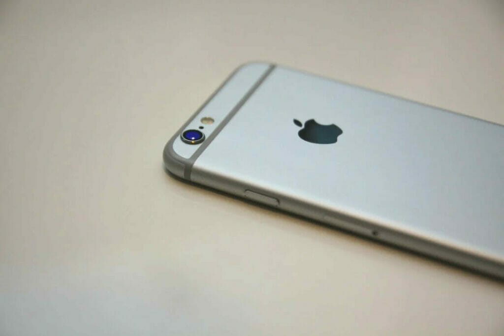 A silver iphone is sitting on a table