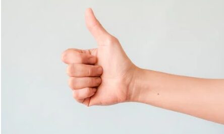 A person's hand showing a thumbs up sign