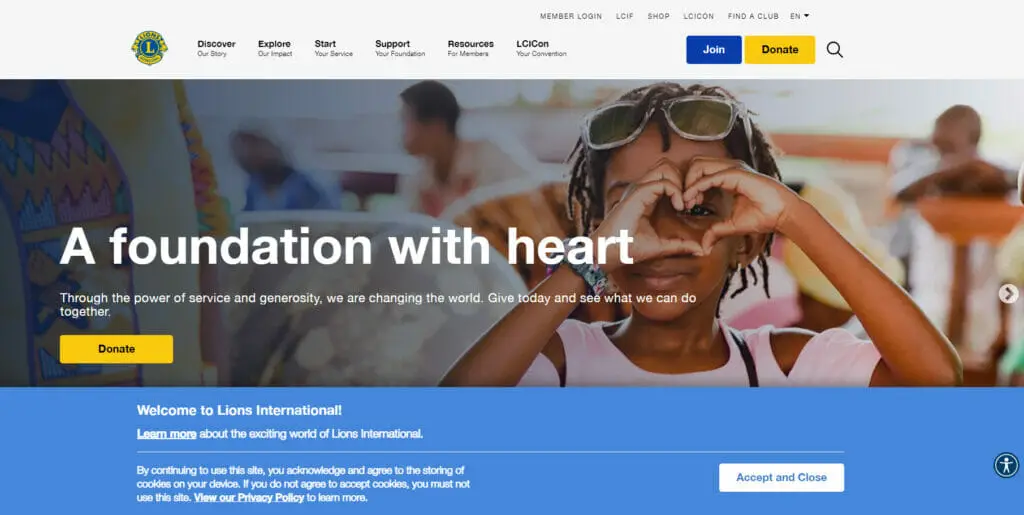 Lions Club International website with a banner of a child posing with a hand heart