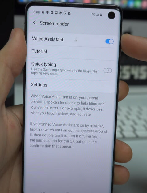 A person holding a phone showing the Screen reader option for Voice Assistant