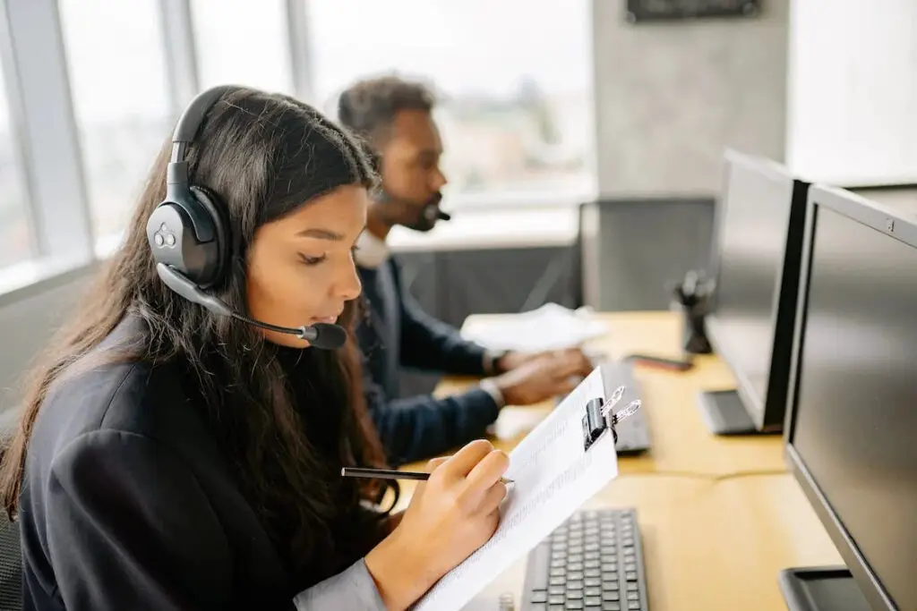 A man and a woman on their headphones working at the office