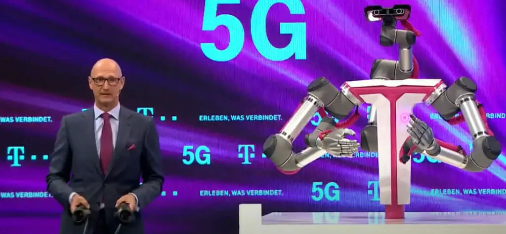 A man in a suit and tie standing in front of a 5g robot